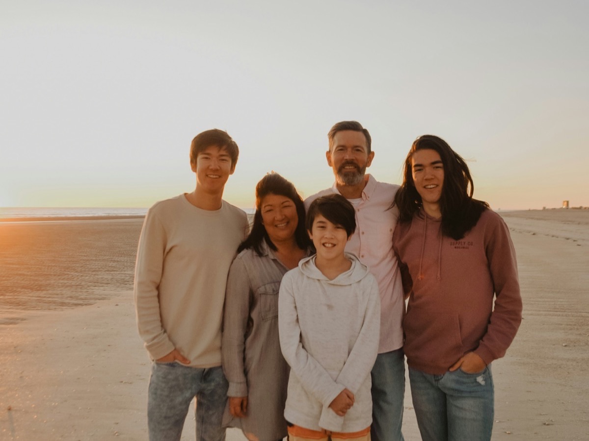 Tres generaciones de una familia juntas en la playa al atardecer